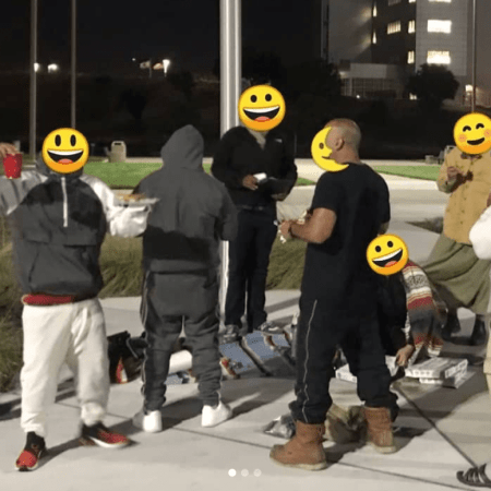 Small group of people with pizza gathered at night in front of Santa Rita Jail